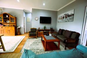 a living room with a couch and a tv at FIG TREE HOUSE Entire holiday home, self catering, 4 bedroom, 2 bathroom, deck and garden in Durban