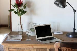 a laptop computer sitting on top of a wooden desk at Elands Bay Beach Villa in Elands Bay