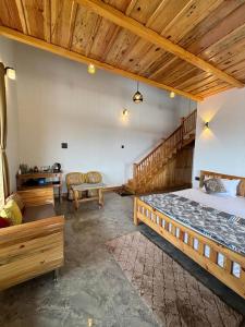 a bedroom with a large bed and a wooden ceiling at Pine Grey Castle in Almora