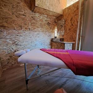 a bed in a room with a stone wall at Bastide de la Couloubre in Mallemort