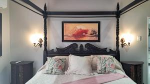 a bedroom with a bed with a black frame at Le Clus Stay in Bloemfontein