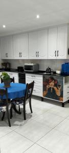 a kitchen with a table with a blue table cloth at Le Clus Stay in Bloemfontein