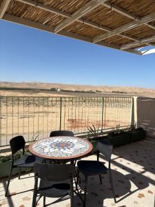 a patio with a table and chairs on a balcony at בקצה הוואדי - The Wadi Edge in Yeroẖam