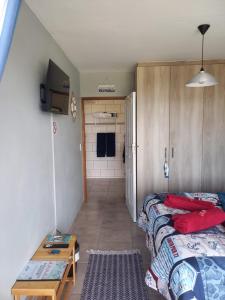 a small room with two beds and a bathroom at Seebossie in Struisbaai