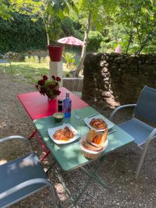 a picnic table with two plates of food and bread at Bastide de la Couloubre in Mallemort