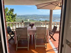a table with chairs and an umbrella on a balcony at VILLA OSTRERA in Suances
