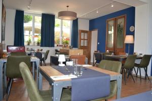 a restaurant with blue walls and tables and chairs at Entre Nous in Rozoy-sur-Serre