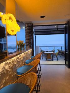 a restaurant with chairs and a table with a view of the ocean at PlayaLolita Beach Resort in Calatagan