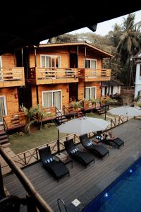 a deck with chairs and umbrellas next to a resort at Tranquillo By The Beach, Candolim in Candolim