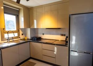 a kitchen with white cabinets and a stainless steel refrigerator at Delux SeaSide Victorious Villa by HolidayKeys in Kyrenia