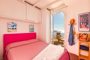 a bedroom with a red bed and a large window at Villino Gelli in Follonica