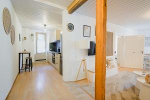 a kitchen and living room with white walls and wood floors at Hostellerie des Princes-Evêques - Le Mystère in Porrentruy