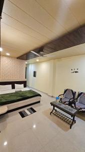 a room with a bed and a couch and a table at Hotel Jai Palace in Pachmarhī