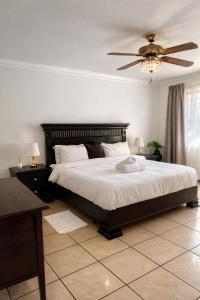 a bedroom with a large bed and a ceiling fan at La Dukes Resort in Bushman Rock +25 photos