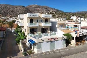 a large white building with a store in front at Smaragdine Beach Hotel in Stalís