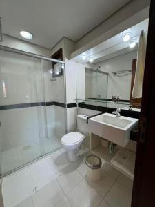 a bathroom with a shower and a toilet and a sink at Beach Front Apartment Kariri in Caucaia