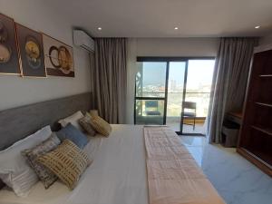 a bedroom with a large white bed with pillows at Ocean Waves Yoff Virage in Dakar +24 photos