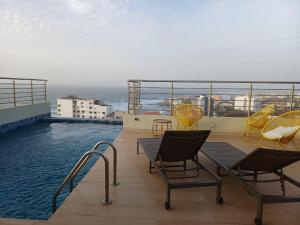 a balcony with chairs and a swimming pool at Ocean Waves Yoff Virage in Dakar
