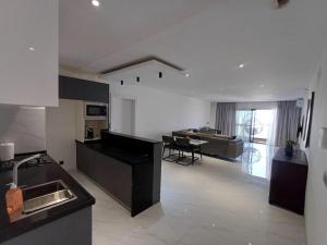 a kitchen and living room with a table and a couch at Ocean Waves Yoff Virage in Dakar