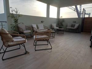 a waiting room with wicker chairs and tables at Ocean Waves Yoff Virage in Dakar