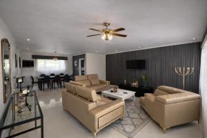 a living room with a couch and a ceiling fan at La Dukes Resort in Bushman Rock