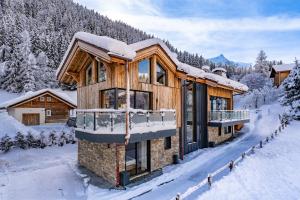 a log cabin in the snow with snow covered trees at Chalet Cotes du Lavancher in Chamonix