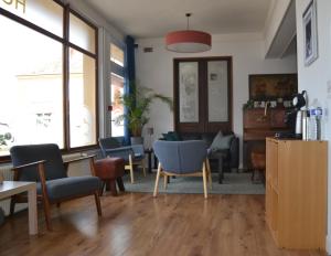 a waiting room with chairs and tables and windows at Entre Nous in Rozoy-sur-Serre