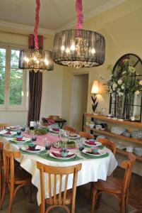 a dining room with a table with chairs and a chandelier at Villa Theodora in Blois