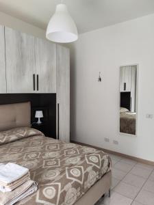a bedroom with a large bed and a mirror at Cavour3 in Nettuno