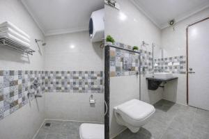 a bathroom with a toilet and a shower and a sink at Olivia Hotels - Delhi Airport in New Delhi +42 photos