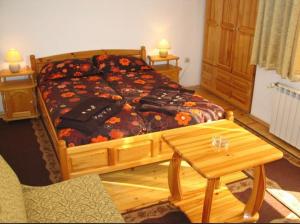 a bedroom with a bed and a wooden table at Hotel Boyanovi in Bansko