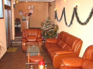 a waiting room with leather furniture and a christmas tree at Hotel Boyanovi in Bansko