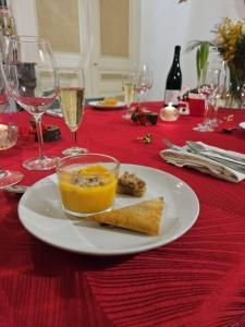 a table with a plate of food on a red table cloth at Aux Chambres des Dames in Chisseaux