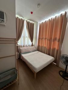 a small room with a bed and a window at Bayanihan Flats 2 in Mactan