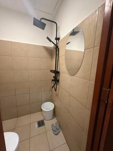 a bathroom with a toilet and a mirror at Bayanihan Flats 2 in Mactan +8 photos