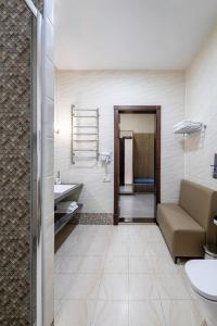 a bathroom with a couch and a sink in a room at Monotel Hotel in Ustʼ-Kamenogorsk