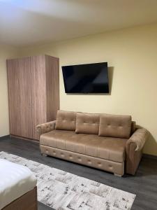 a living room with a couch and a flat screen tv at Apartamentele Liliacul in Sighetu Marmaţiei