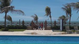 two people walking a dog by a swimming pool at Beach Front Apartment Kariri in Caucaia +7 photos