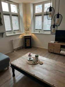 a living room with a wooden coffee table with flowers on it at Warendorf 14 in Warendorf