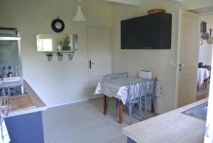 a kitchen with a table with chairs and a clock on the wall at Villa Theodora in Blois