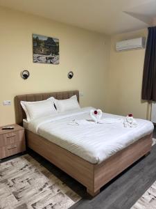 a bedroom with a bed with towels on it at Apartamentele Liliacul in Sighetu Marmaţiei