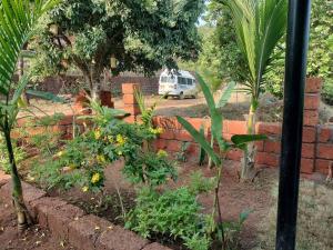 a garden with some plants and a brick wall at Devrai Villa in Dapoli
