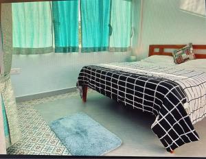 a bedroom with a bed with a plaid blanket and a rug at Devrai Villa in Dapoli