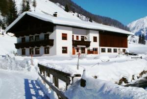een huis bedekt met sneeuw voor de deur bij Saxerhof in Schmirn