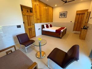 a bedroom with a bed and a table and chairs at The Lazymojo in Tāla