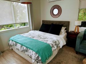 a bedroom with a bed and a mirror on the wall at Private Beachside Studio with Courtyard and Sea view in Paraparaumu