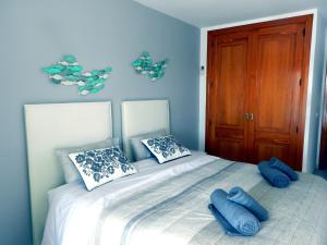 a bedroom with a bed with blue pillows on it at Harmony Seafront 365 by Can Ventet in Port de Pollensa