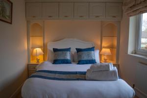 a bedroom with a large white bed with blue pillows at Farnborough Stay - 5 Bedrooms in Farnborough