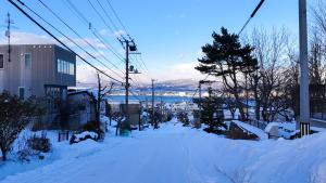 a street covered in snow with a ski lift at 9Stay函館 in Hakodate