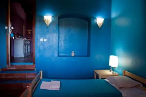 a blue bedroom with a bed and a table with a lamp at Ecoland Casa de Campo in Mértola